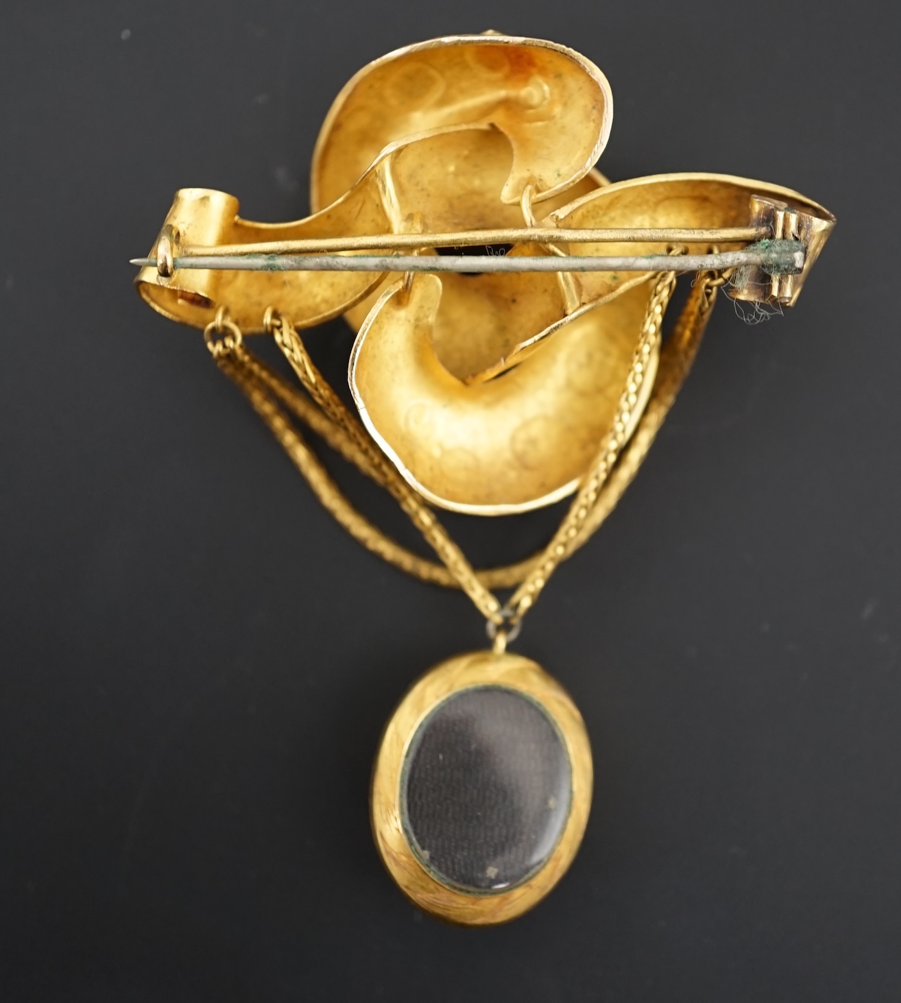 A Victorian textured gold and garnet cluster set drop 'knot' brooch